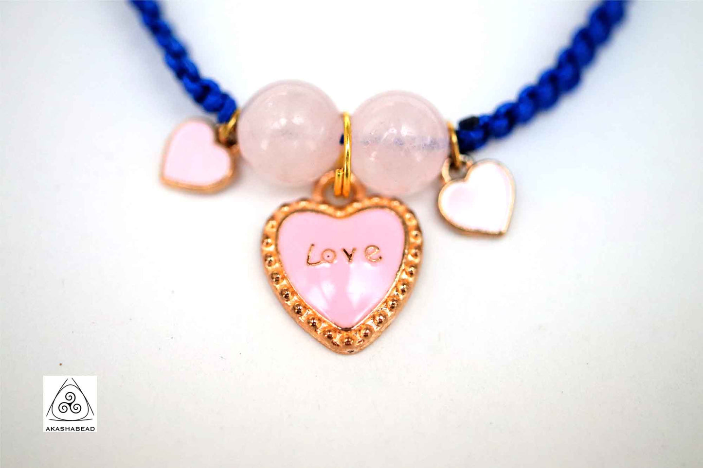 Braided bracelet with pink heart charm and love charm